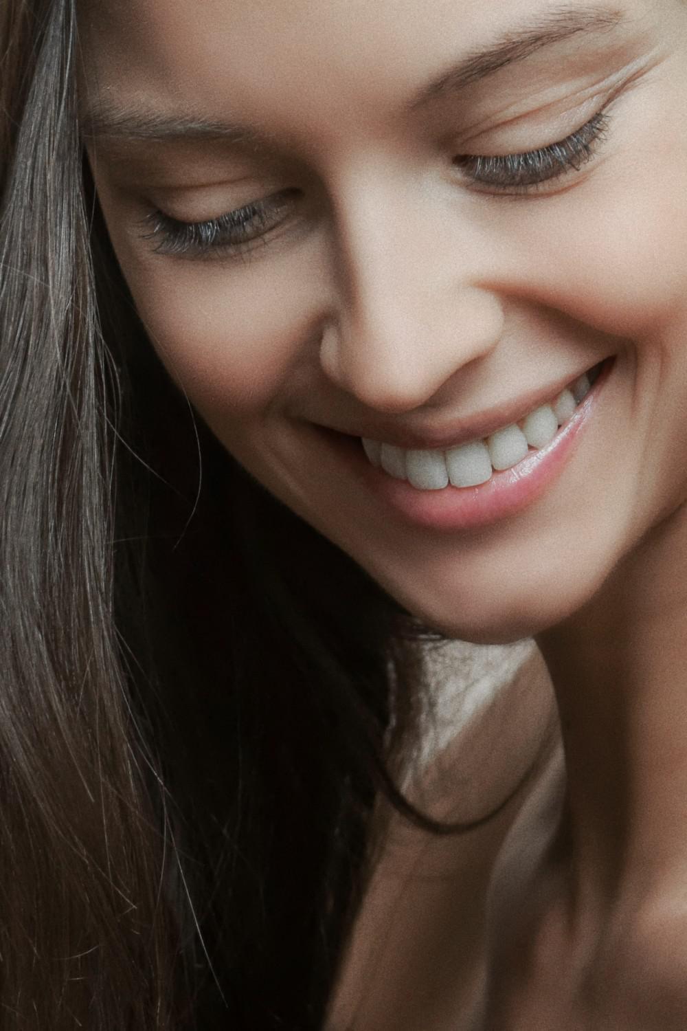 closeup picture of a woman with healthy skin smiling