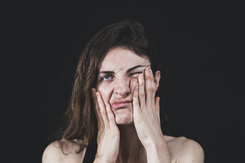 woman pushing around her face skin with her hands
