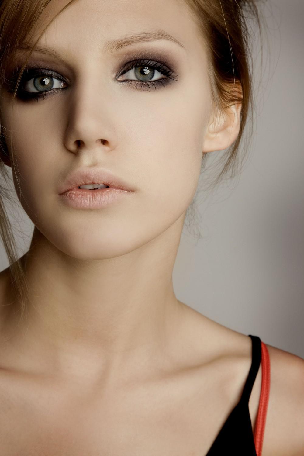 young woman with smooth skin and dark, dramatic eye makeup