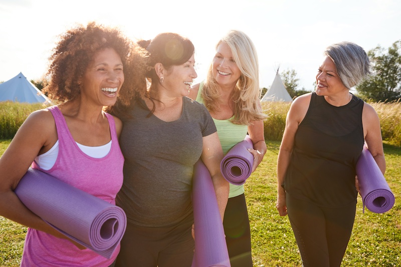 Group Of women Friends On Outdoor Yoga Retreat walking together and smiling